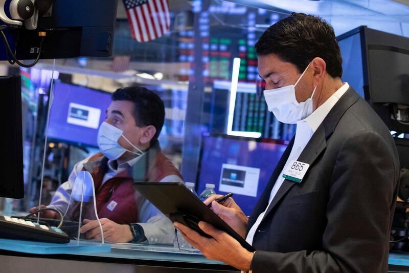 In this photo provided by the New York Stock Exchange, trader Mark Muller, right, and specialist Peter Mazza work on the trading floor, Wednesday, March 24, 2021. Stocks were moving mostly higher on Wednesday, helped by a recovery of bank and industrial stocks. Bond yields were steady after rising earlier this week. (Nicole Pereira/New York Stock Exchange via AP)