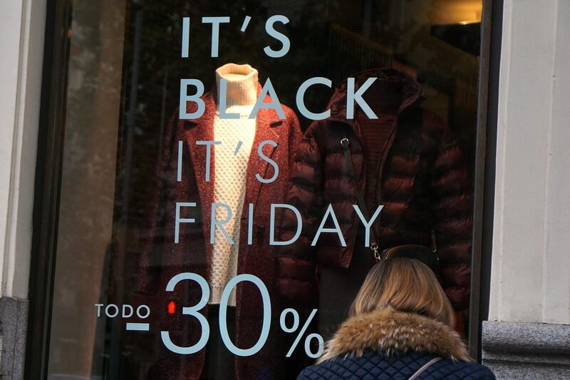 A shopper walks past a promotional sign for "Black Friday" sales in Madrid.  Gabriel Bouys / AFP Photo