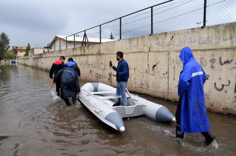 Iraqis prepare a dinghy boat to use a a means of transportation in a street flooded by heavy rain in the northern Iraqi city of Mosul. AFP