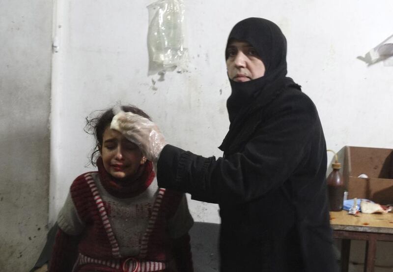 A woman tends to a wounded girl after what activists said was an airstrike by forces loyal to Syria’s president Bashar Al Assad, in the Damascus suburb of Saqba on December 26, 2014. Reuters