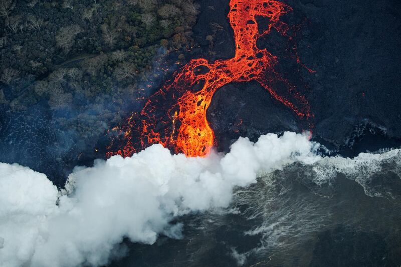 A massive flow of lava enters the sea at Malama Flats, Hawaii, leaving a stretch of a major coastal road cut off at both ends. The ongoing eruption of Kilauea is the largest in decades, destroying more than 40 homes to date, and displacing thousands. Bruce Omori / EPA