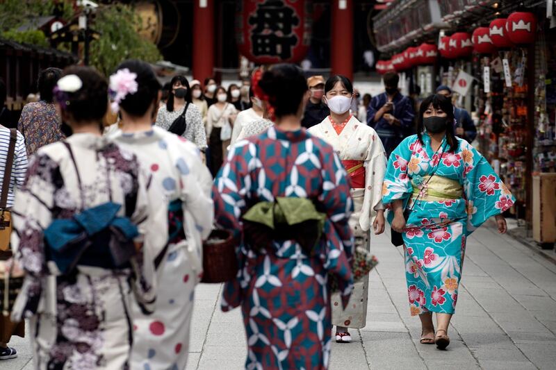 People wearing protective masks to help curb the spread of the coronavirus walk at a shopping arcade at Asakusa district, Tokyo. The Japanese capital confirmed more than 200 coronavirus cases on Tuesday. AP Photo