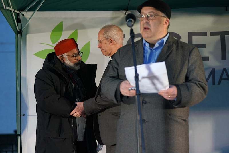 Imam Hussain and Rev Welby shake hands as Rabbi Mason speaks to the vigil. PA 