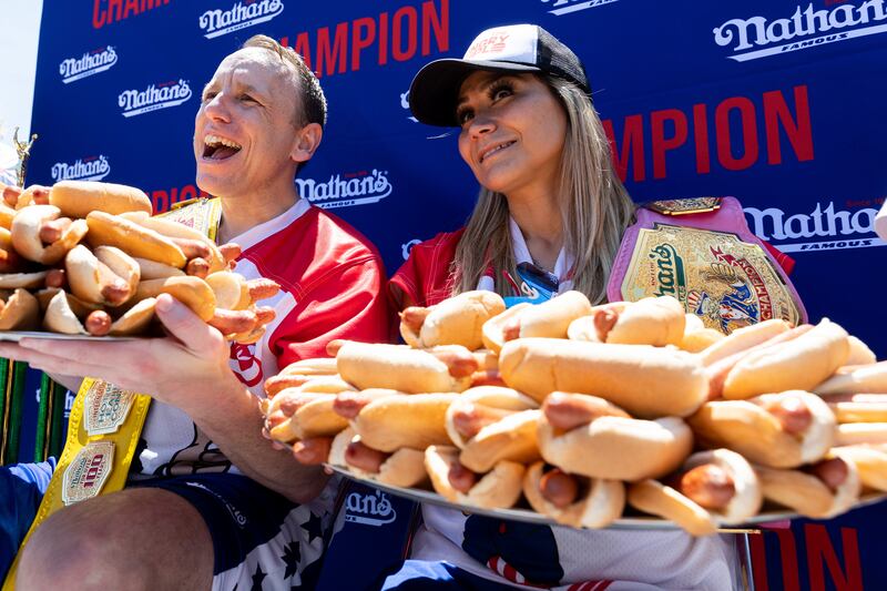 Mr Chestnut and women's champ Miki Sudo pose with 63 and 40 hot dogs, respectively, after winning the Nathan's Famous Fourth of July hot dog eating contest. AP