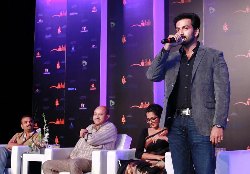 Parvathy, in a black sari, and Prithviraj, standing at the Sharjah book festival. Victor Besa for The National