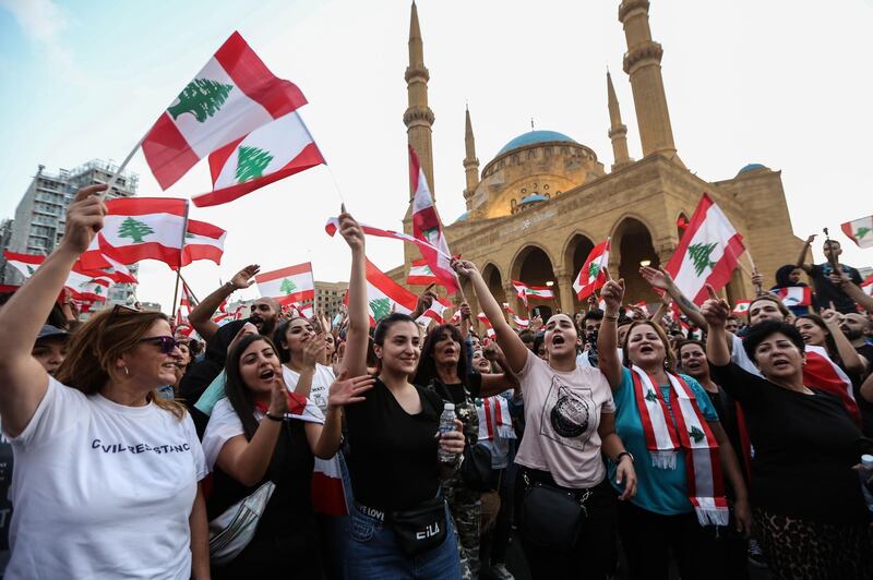Protesters wave flags and shout anti-government slogans during a protest in front the Government palace in downtown Beirut. EPA
