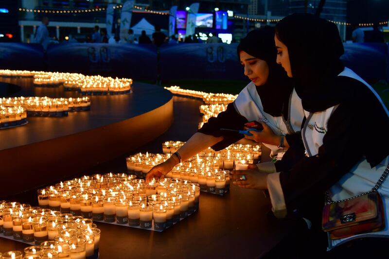 Two women light candles after the building lights were switched off for the Earth Hour environmental campaign in Dubai on March 24, 2018.
Earth Hour, which started in Australia in 2007, is set to be observed by millions of supporters in 187 countries, who will turn off their lights at 8.30pm local time in what organisers describe as the world's "largest grassroots movement for climate change". / AFP PHOTO / Giuseppe CACACE