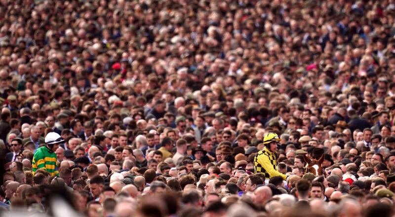 Jockey Bryan Cooper makes his way through the packed crowds on Bring On the Night during day one of the Cheltenham Festival in England. PA