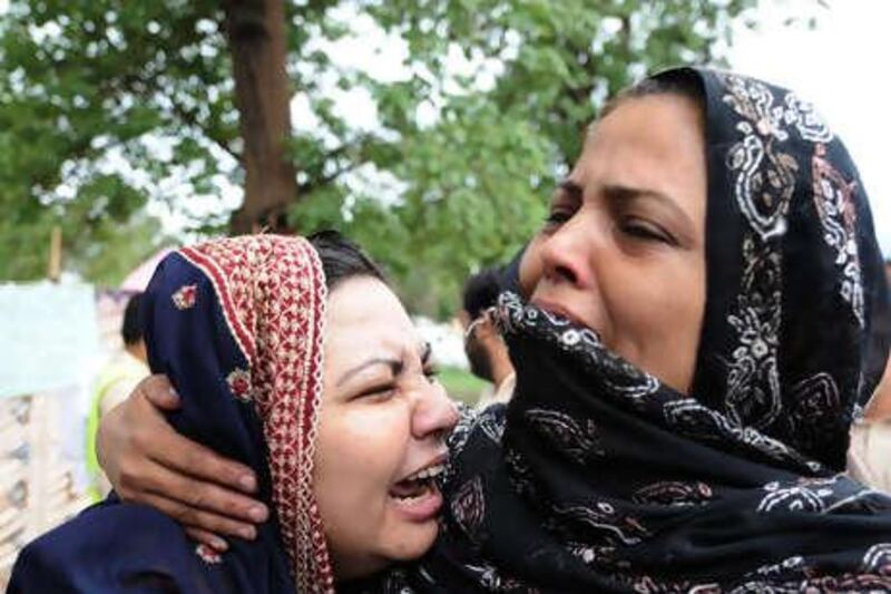 Pakistani women mourn their father, after his death in a plane crash in The Margala Hills on the outskirts of Islamabad on July 28, 2010. Pakistan has declared a day of national mourning and called off a cabinet meeting after a passenger jet with 150 on board crashed into hills outside the capital Islamabad.  AFP PHOTO/AAMIR QURESHI