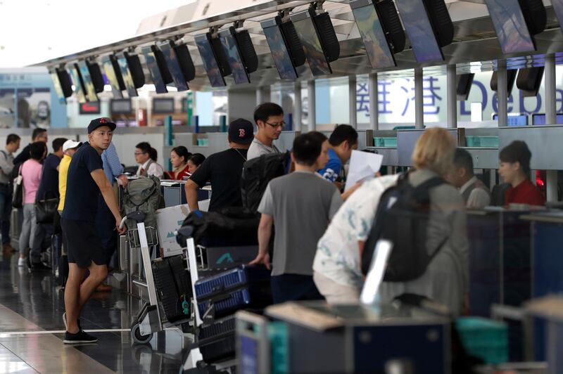 Travellers check in on their flights at the airport in Hong Kong. AP Photo