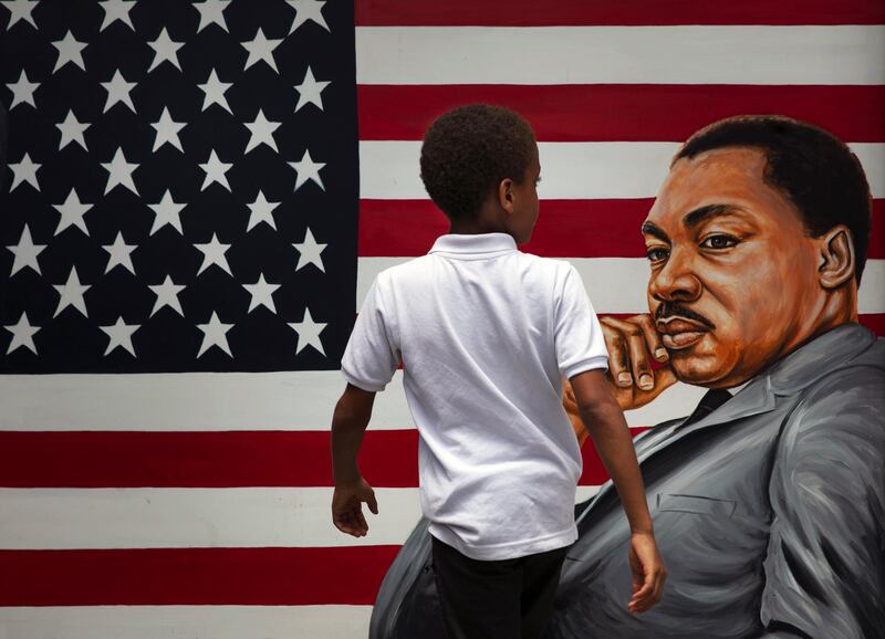 A boy walks past a painting depicting Dr Martin Luther King Jr during a Juneteenth celebration in Los Angeles, US. AP