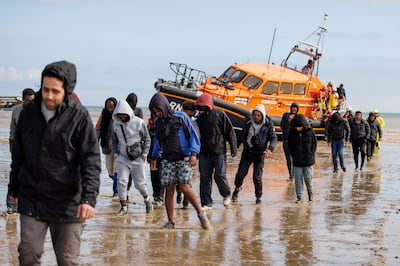 Migrants rescued from a small boat crossing the English Channel land on Dungeness Beach in Kent, south-east England. EPA 