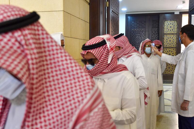 A Saudi medical worker checks the temperature of worshippers in Riyadh. AFP