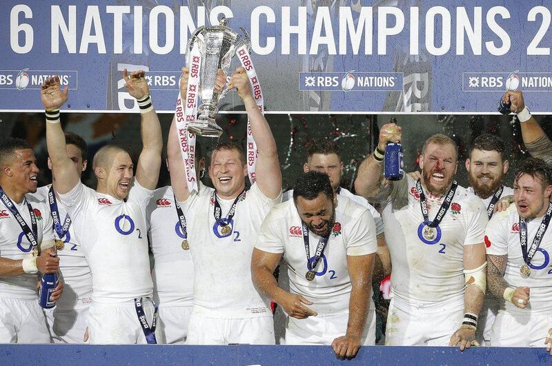 England's Dylan Hartley holds the trophy aloft as he celebrates with teammates after the Six Nations international rugby match between France and England at the Stade de France stadium in Saint-Denis, outside Paris, Saturday, March 19, 2016. England won the game to clinch the Grand Slam. (AP Photo/Christophe Ena)