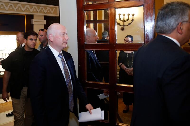 Jason Greenblatt (C), US President Donald Trump's Middle East envoy, is reflected in a mirror as he enters a room to hold a news conference with Israeli Minister of Regional Cooperation and the head of the Palestinian Water Authority, in Jerusalem on July 13, 2017. / AFP PHOTO / POOL / RONEN ZVULUN