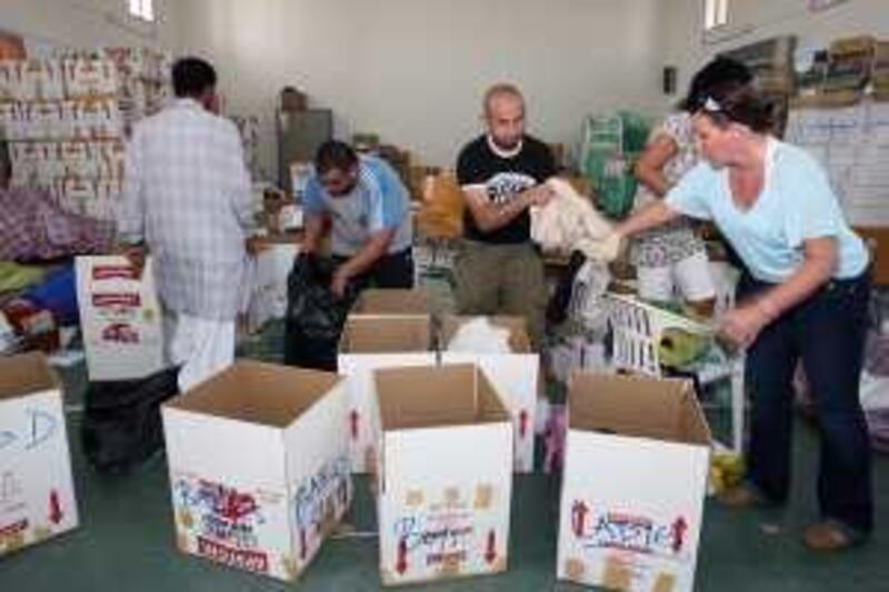DUBAI, UNITED ARAB EMIRATES - JUNE 1:  Volunteers sorting through aid donations for the Swat Valley refugees in Pakistan at the Pakistani Association in Dubai on June 1, 2009. The donations included medicine, clothing, water and food and will be shipped out to Pakistan later today. The volunteer fund raising drive will continue throughout the month. Pictured are from left: Shadi El Khatib, Kabul Wazir Mir, who both organized the drive, and Gabriele Shaw, a volunteer.  (Randi Sokoloff / The National)  For News story/standalone *** Local Caption ***  RS001-060109-SWAT-AID.jpgRS001-060109-SWAT-AID_Cropped.jpg