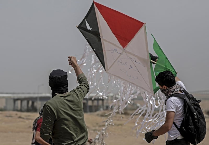 epa06682550 Palestinians protesters fly a kite with Molotov cocktail during clashes near the Israel border in the east of Gaza City, 20 April 2018 (issued 21 April 2018). Two Palestinian protesters have been killed and more than 120 others wounded during the clashes near the Israel border and Gaza Strip.  EPA/MOHAMMED SABER