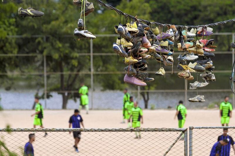 Discarded soccer boots hang from an electric wire. Washington Alves / Reuters