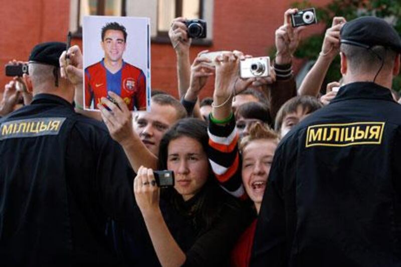 A Barcelona fan holds a portrait of Xavi while others take pictures amid tight security after the team’s arrival in Minsk on Tuesday. Barca, who beat local favourites BATE Borisov on Wednesday, have a huge fan following all over the world for the brand of football they play.