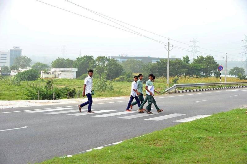 Students cross National Highway 44 to go to school in the village of Peddakunta. Noah Seelam / AFP
