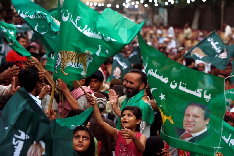 A child supporter of Shahbaz Sharif, brother of ex-prime minister Nawaz Sharif, and leader of Pakistan Muslim League - Nawaz (PML-N) waves party flags with others to welcome him during a campaign rally ahead of general elections in the Lyari neighborhood in Karachi, Pakistan June 26, 2018. REUTERS/Akhtar Soomro