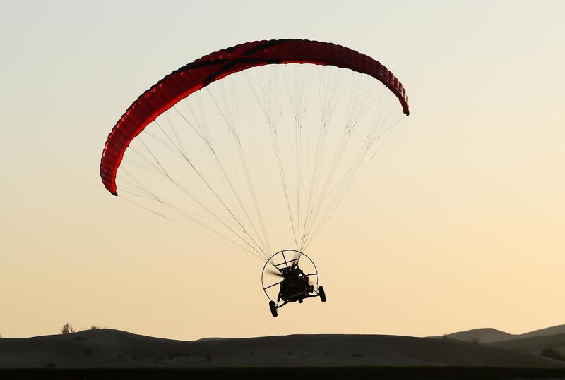 DUBAI, UNITED ARAB EMIRATES , January 13 – 2021 :- Pilot Alexandr Ctitor flying after the sunrise at the Paramotor Desert Adventure Aviation Club on Dubai- Al Ain road in Dubai. (Pawan Singh / The National) For News/Online. Story by Sarwat