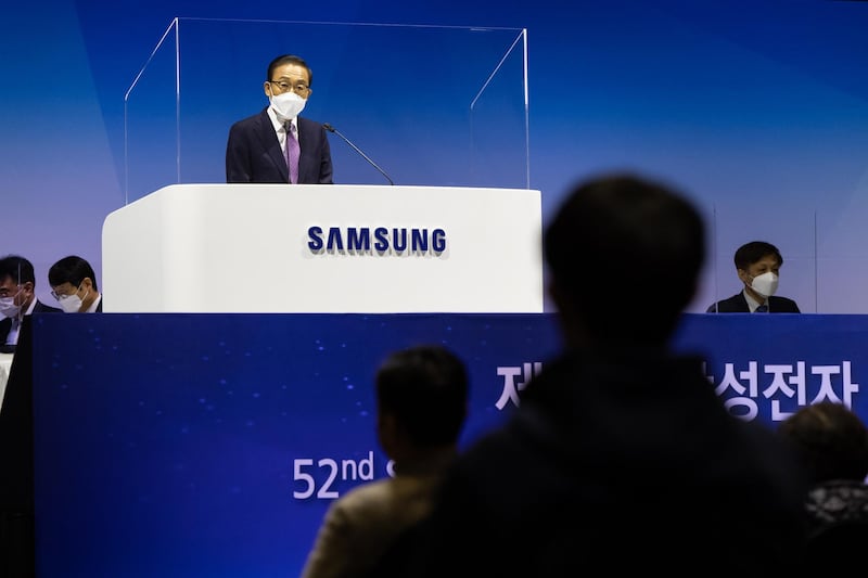 Kim Ki-nam, co-vice chairman and co-chief executive officer of Samsung Electronics Co., speaks from behind a transparent screen during the company's annual general meeting at the Suwon Convention Center in Suwon, South Korea. Huawei Technologies Co. will begin charging mobile giants like Samsung a "reasonable" fee for access to its trove of wireless 5G patents, potentially creating a lucrative revenue source by showcasing its global lead in next-generation networking. Bloomberg
