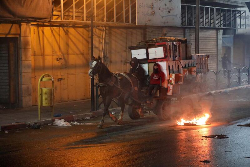 Palestinians bring materials on a horse drawn cart to build a burning barricade as they clash with Israeli security forces during a protest against US President Donald J. Trump's Middle East peace plan to solve the conflict between Palestinians and Israel, near the West Bank City of Hebron.  EPA