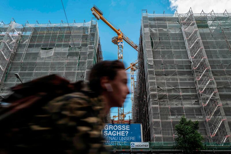 A cyclist passes a building construction site in Berlin's Mitte district on May 28, 2020.  / AFP / John MACDOUGALL
