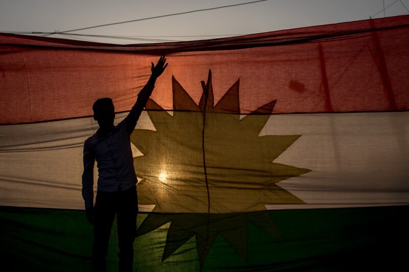 A man in front of a Kurdish flag during a protest outside the US Consulate in Erbil, Iraq, in 2017. Getty Images