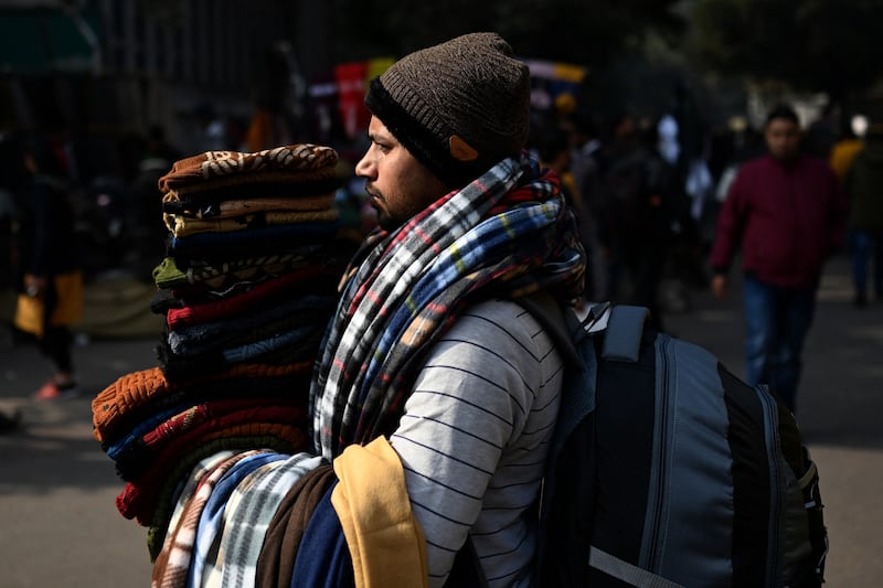 A vendor sells wooly hats and scarves. AFP