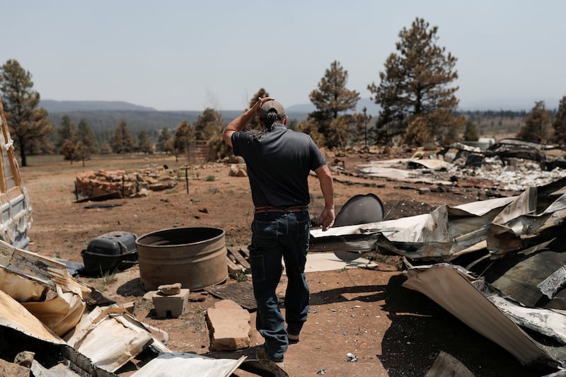 A man walks through his property, burnt during the Hermits Peak and Calf Canyon fires. Reuters