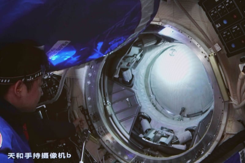 Chinese astronaut Chen Dong opens the hatch door of the Wentian lab module on July 25, 2022.  Photo:  Xinhua News Agency