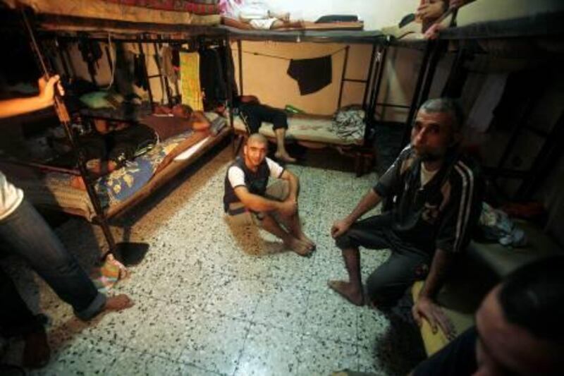 Palestinian inmates sit inside the new jail controlled by the Hamas police in Gaza City August 5, 2009. The jail was opened after Gaza's main prison was destroyed during the three-week offensive Israel launched last December. REUTERS/Mohammed Salem (GAZA POLITICS CRIME LAW) *** Local Caption ***  JER03_PALESTINIANS-_0805_11.JPG