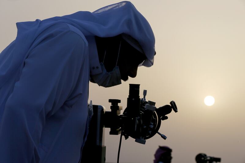 A member of the moon sighting committee looks through a telescope to view the moon ahead of Ramadan to mark the beginning of the holy fasting month, near Riyadh, Saudi Arabia, April 12, 2021. REUTERS/Ahmed Yosri     TPX IMAGES OF THE DAY