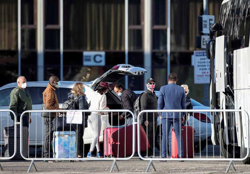 People wait to board the coach after finishing quarantine, as Britain introduces a hotel quarantine programme for arrivals from a "red list" of 30 countries due to the coronavirus disease (COVID-19) pandemic, in London, Britain, February 26, 2021. REUTERS/Peter Cziborra