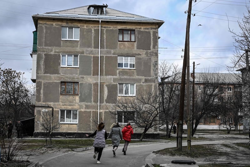 Three women run for cover during shelling in Schastia, eastern Ukraine. AFP