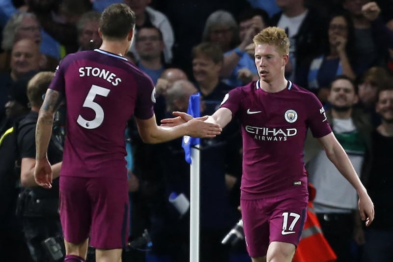 Manchester City's Belgian midfielder Kevin De Bruyne (R) celebrates with Manchester City's English defender John Stones after scoring the opening goal of the English Premier League football match between Chelsea and Manchester City at Stamford Bridge in London on September 30, 2017. (Photo by Ian KINGTON / AFP) / RESTRICTED TO EDITORIAL USE. No use with unauthorized audio, video, data, fixture lists, club/league logos or 'live' services. Online in-match use limited to 75 images, no video emulation. No use in betting, games or single club/league/player publications. / 
