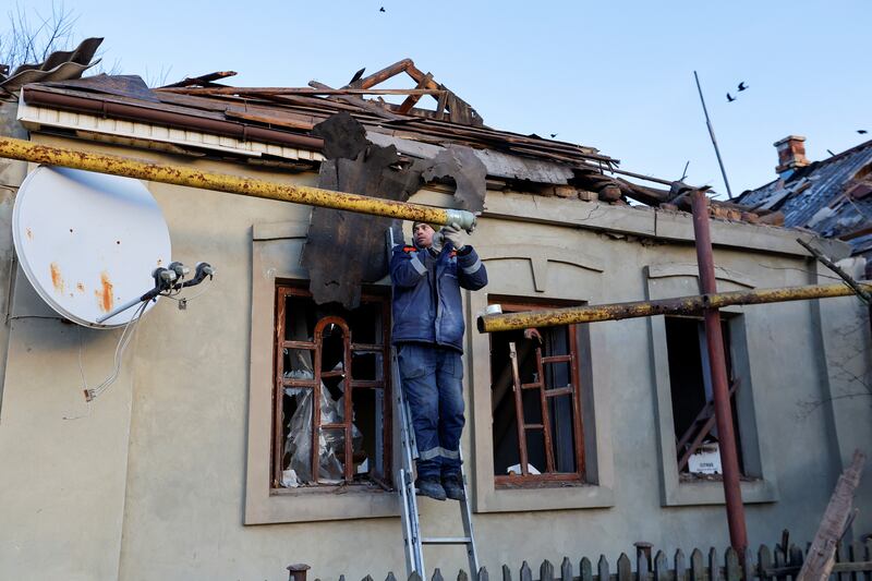A specialist from an emergency crew works on a residential building in Donetsk that was damaged in recent shelling. Reuters