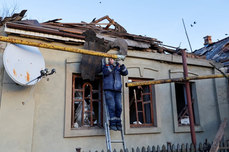 A specialist from an emergency crew works on a residential building in Donetsk that was damaged in recent shelling. Reuters