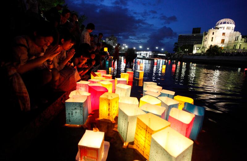 People pray after releasing paper lanterns on a river facing the gutted Atomic Bomb Dome in remembrance of atomic bomb victims on the 66th anniversary of the bombing in Hiroshima August 6, 2011. Prime Minister Naoto Kan on Saturday took his campaign against nuclear energy in Japan to Hiroshima which 66 years ago became the world's first victim of an atomic bomb.   REUTERS/Kim Kyung-Hoon (JAPAN - Tags: CONFLICT POLITICS MILITARY ANNIVERSARY IMAGES OF THE DAY) *** Local Caption ***  TOK721_JAPAN-NUCLEA_0806_11.JPG