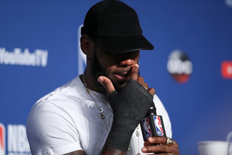 Cleveland Cavaliers forward LeBron James wipes his face with a bandaged hand during a news conference following Game 4 of basketball's NBA Finals. Carlos Osorio / AP Photo