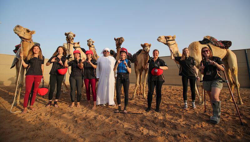 Obaid Al Falasi, centre, the owner of the centre, with riders after the final of the Female Camel Racing Series C1 Championship.