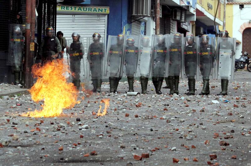 Security forces look on while clashing with opposition supporters in Tachira, Venezuela. Reuters