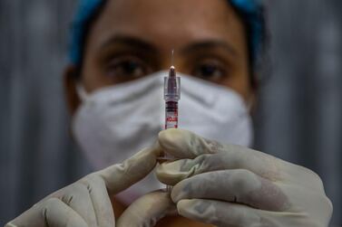 A health worker checks a syringe before performing a Covid-19 vaccine trial in Gauhati, India. The country has approved two vaccines for emergency use so far - Covishield, a local variant of the Oxford University / AstraZeneca shot and the Covaxin treatment created by Bharat Biotech. AP Photo