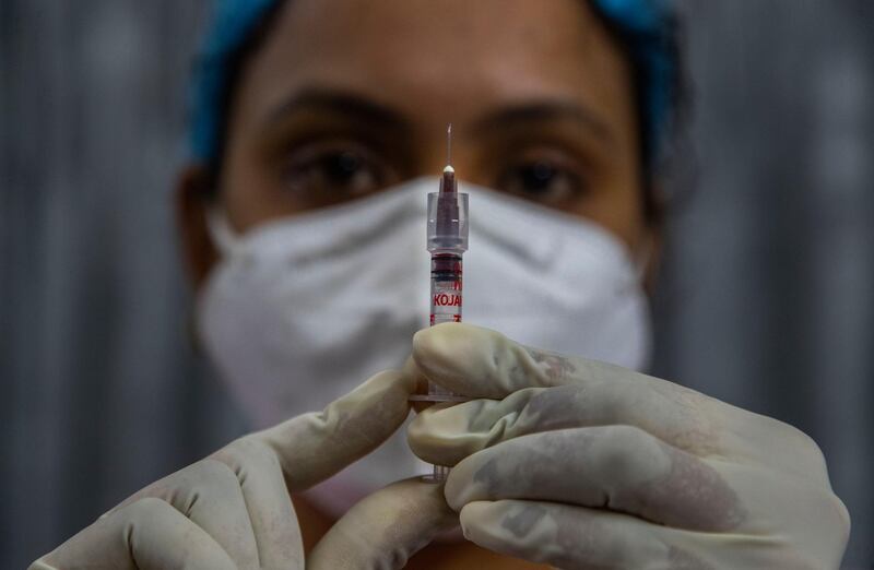 A health worker checks a syringe before performing a trial run of COVID-19 vaccine delivery system in Gauhati, India, Friday, Jan. 8, 2021. India is testing its COVID-19 vaccine delivery system as it prepares to roll-out an inoculation program to stem the coronavirus pandemic. The exercise included necessary data entry into an online platform for monitoring vaccine delivery, along with testing of cold storage and transportation arrangements for the vaccine, according to the health ministry. (AP Photo/Anupam Nath)