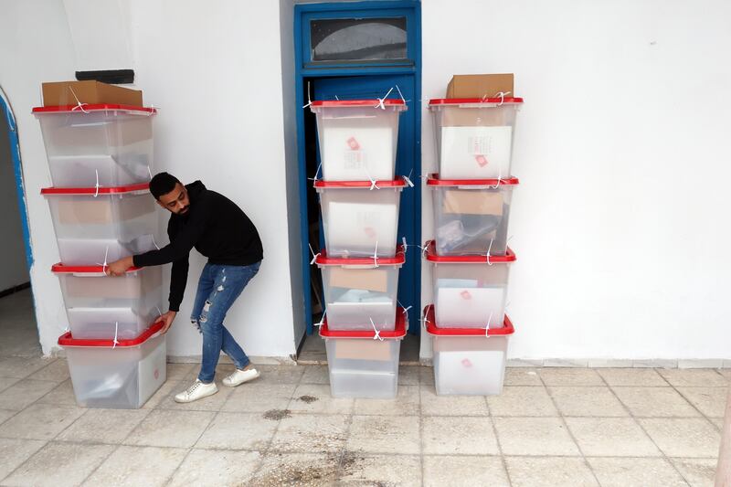 A worker from Tunisia's Independent High Authority for Elections checks ballot boxes into a polling station in Tunis on Friday. EPA