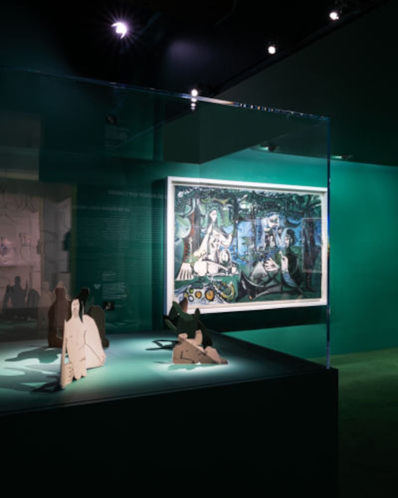 A dark green room displays Picasso artworks