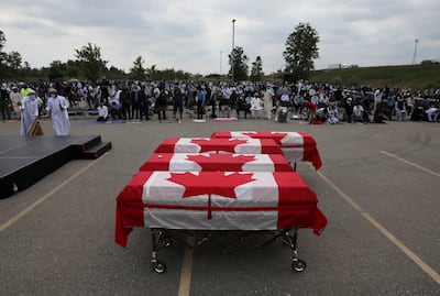 Flag-wrapped coffins are seen outside the Islamic Centre of Southwest Ontario during the funeral for the Afzaal family in June 2021. Reuters