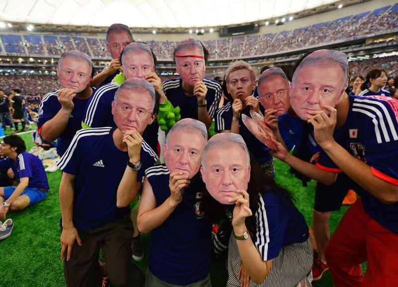 Japanese football supporters wear masks of Japan's head coach Alberto Zaccheroni before the starting of the Group C match against Ivory Coast at the 2014 World Cup on Sunday. Yoshikazu Tsuno /AFP